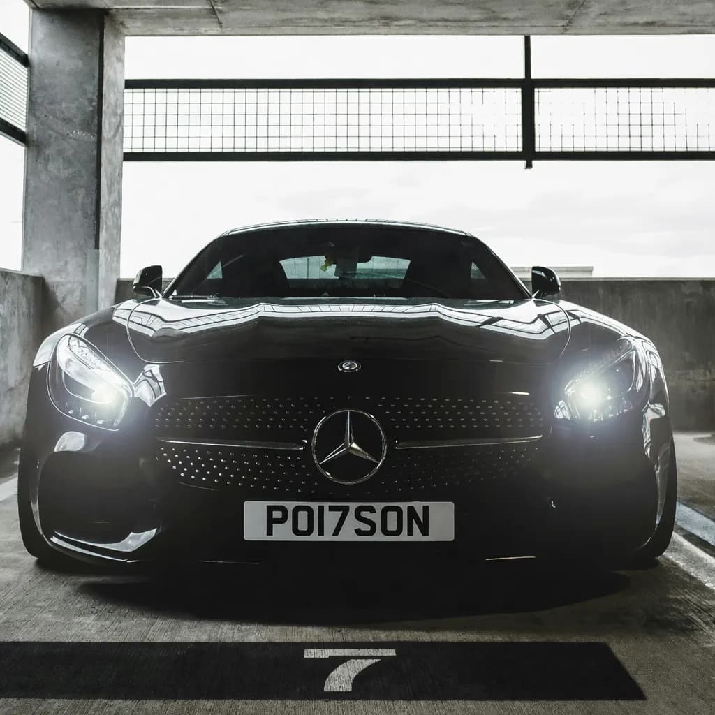 Photo of a glossy Obsidian Black Mercedes-AMG GT showing the private number plate PO17 SON, which reads as Poison and is currently available for sale for £15,250.